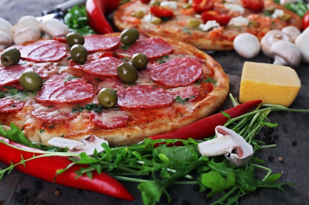 Heerlijke smakelijke pizza met ingrediënten op tafel close-up