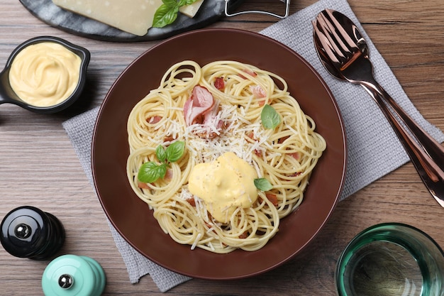 Heerlijke spaghetti met kaassaus en vlees geserveerd op houten tafel plat gelegd