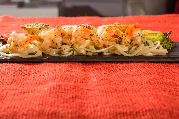 Heerlijke spaghettisalade met garnalen, tomaat en pupunha palm.