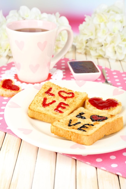 Heerlijke toast met jam en kopje thee op tafel close-up