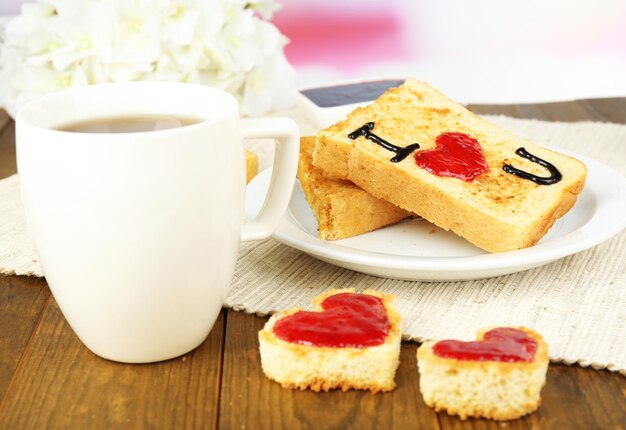 Heerlijke toast met jam en kopje thee op tafel close-up