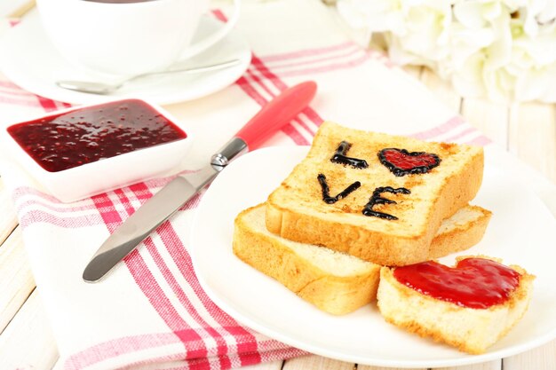 Heerlijke toast met jam en kopje thee op tafel close-up