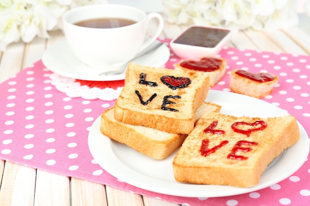 Heerlijke toast met jam en kopje thee op tafel close-up