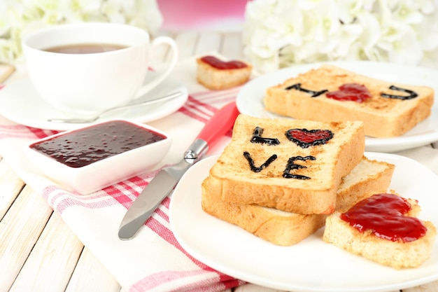 Heerlijke toast met jam en kopje thee op tafel close-up