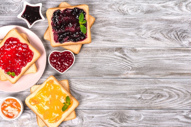 Heerlijke toast met verschillende zoete jam op grijs