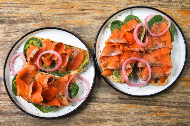 Heerlijke toastjes met gerookte zalm, avocado en basilicumblaadjes