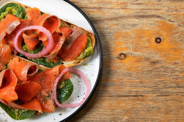 Heerlijke toastjes met gerookte zalm, avocado en basilicumblaadjes