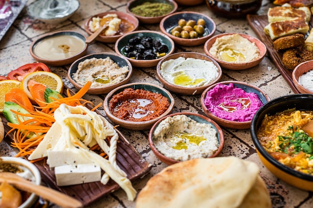 Heerlijke Turkse familieontbijttafel met gebak, groenten, greens, spreads, kazen, gebakken eieren, jam. Bovenaanzicht.