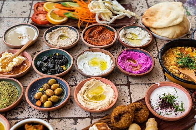 Heerlijke Turkse familieontbijttafel met gebak, groenten, greens, spreads, kazen, gebakken eieren, jam. Bovenaanzicht.