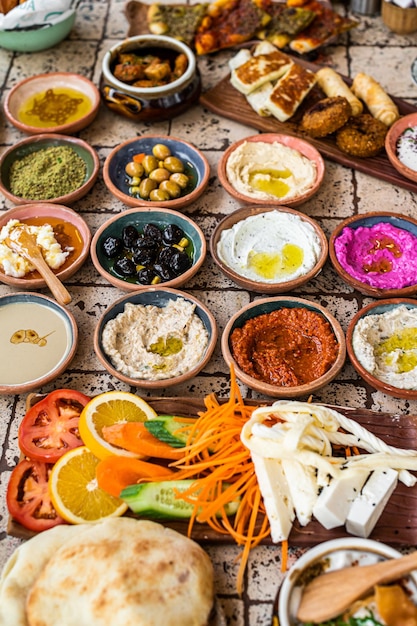 Heerlijke Turkse familieontbijttafel met gebak, groenten, greens, spreads, kazen, gebakken eieren, jam. Bovenaanzicht.