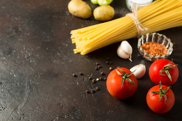 Heerlijke variëteit aan rauwe pasta met verse tomaten en op bruine tafel