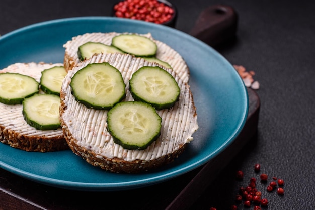 Heerlijke vegetarische boterham met gegrilde toast, roomkaas, komkommers en zaden.