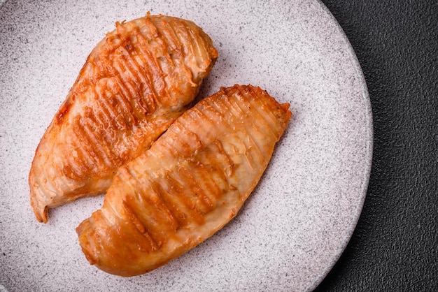 Heerlijke vers gegrilde kipfilet met specerijen en kruiden op een donkere betonnen achtergrond