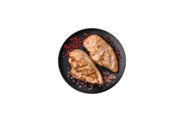 Heerlijke vers gegrilde kipfilet met zoute specerijen en kruiden op een keramische plaat op een donkere betonnen ondergrond