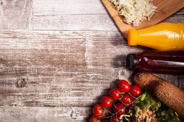 Heerlijke verse gegrilde kip op een houten bord naast gezond brood, tomaten en salade. gezonde levensstijl en eten