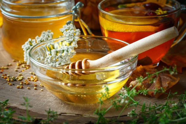 Heerlijke verse honing en een kopje gezonde thee met lemonnd rozenbottels op houten tafel. Selectieve aandacht.