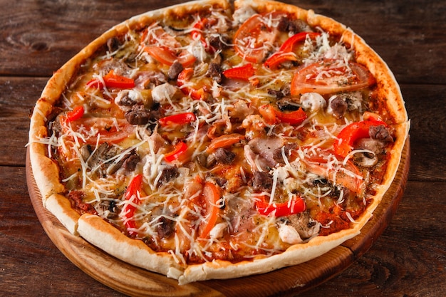 Heerlijke verse kleurrijke pizza geserveerd op houten rustieke tafel, bovenaanzicht. Italiaans restaurant menu foto.
