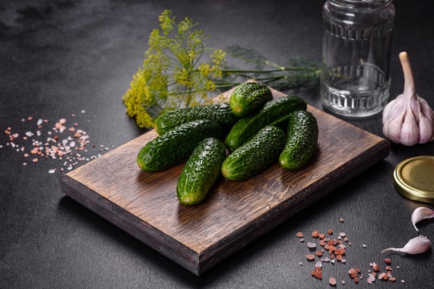 Heerlijke verse komkommers met knoflookzoutkruiden en kruiden op een houten snijplank