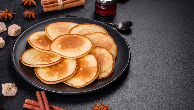 Heerlijke verse pannenkoeken op een houten snijplank met suiker op een donkere betonnen ondergrond