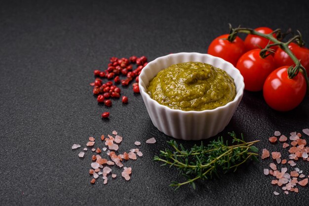 Heerlijke verse pasta bestaande uit pestosaus met zoute specerijen en kruiden op een donkere betonnen achtergrond