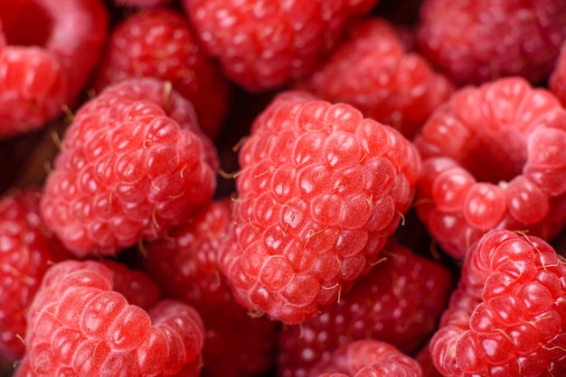 Heerlijke verse, sappige rode frambozen op een donkere tafel. Seizoensbessen en fruit