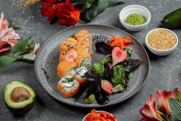 Heerlijke verse sushibroodjes met zalm en de kaas van philadelphia op grijze plaat