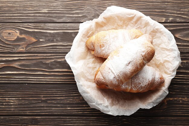 Heerlijke warme croissants op houten achtergrond. Plaats voor tekst.