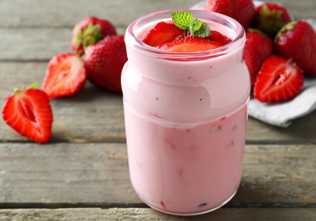 Heerlijke yoghurt smoothie met aardbei op houten achtergrond