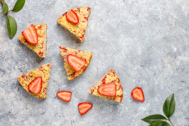 Heerlijke zelfgemaakte aardbei crumble cake met verse aardbeien plakjes, bovenaanzicht