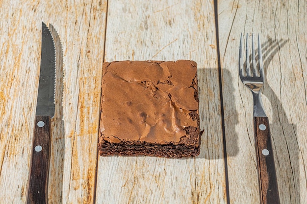 Heerlijke zelfgemaakte chocolade brownie boven tafel met vork en mes lekker chocolade dessert