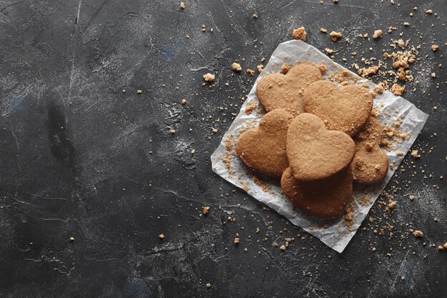 Heerlijke zelfgemaakte koekjesharten op een donkere achtergrond. Bovenaanzicht. Plaats voor tekst.