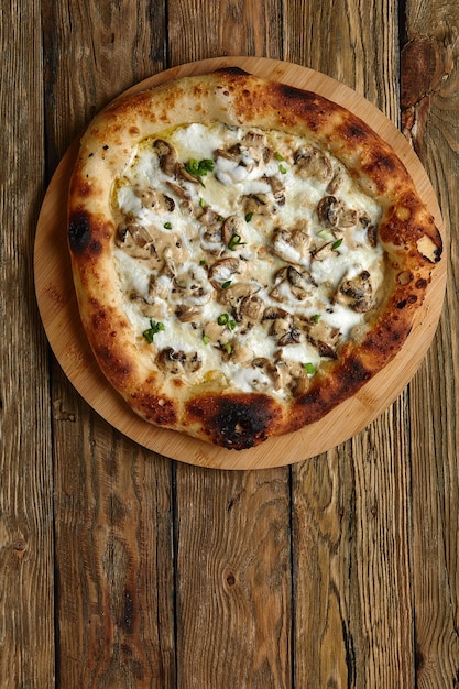 Heerlijke zelfgemaakte pizza met mozzarella, champignons, rundvlees en kip Houten achtergrond selectieve focus