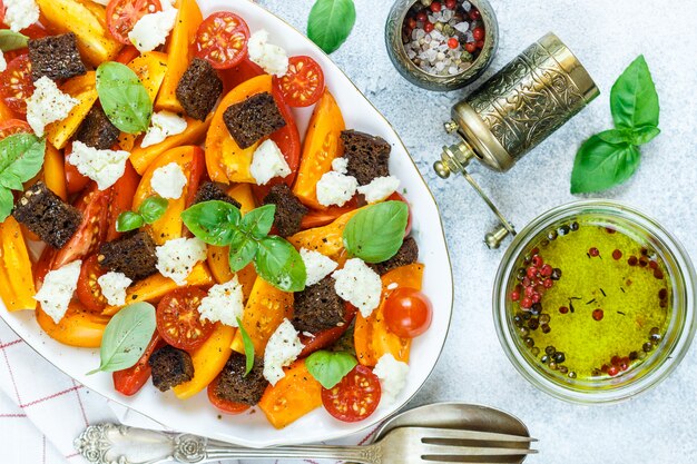 Heerlijke zomersalade van gele en rode tomaten, croutons, kaasmozzarella, basilicum en olijfolie