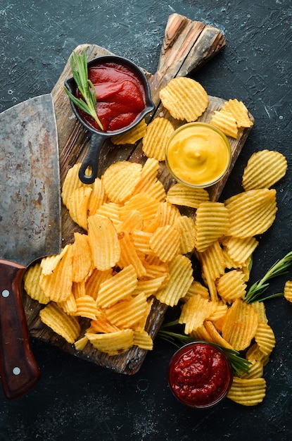 Heerlijke zoute chips Biersnacks op een zwarte stenen achtergrond Bovenaanzicht Vrije ruimte voor uw tekst