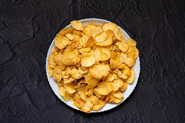 Heerlijke zoute chips Biersnacks op een zwarte stenen achtergrond Bovenaanzicht Vrije ruimte voor uw tekst