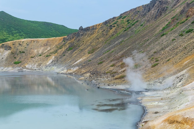 Heet gemineraliseerd meer met thermale bron en rokende fumarolen in de caldera van de golovnin-vulkaan op het eiland kunashir