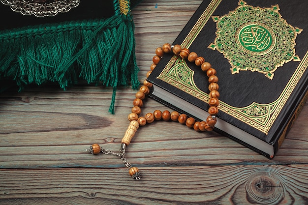 Heilige Koran met kralen over houten oppervlak