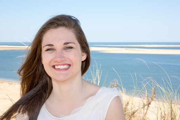 Helder beeld van gelukkig lachende vrouw op het strand.