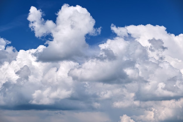Helder landschap van witte gezwollen cumuluswolken op blauwe heldere hemel
