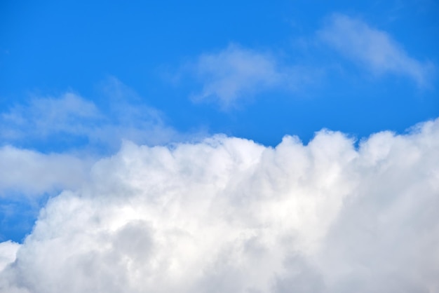 Helder landschap van witte gezwollen cumuluswolken op blauwe heldere hemel