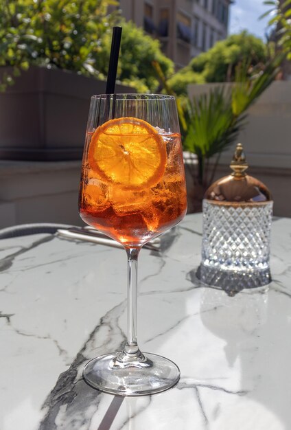 Helder oranje cocktail in glas met ijs en oranje Selectieve focus