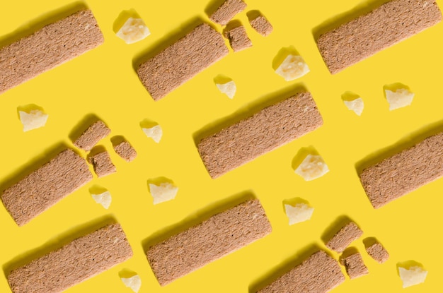 Helder patroon met gezonde snack en Parmezaanse kaas op gele achtergrond