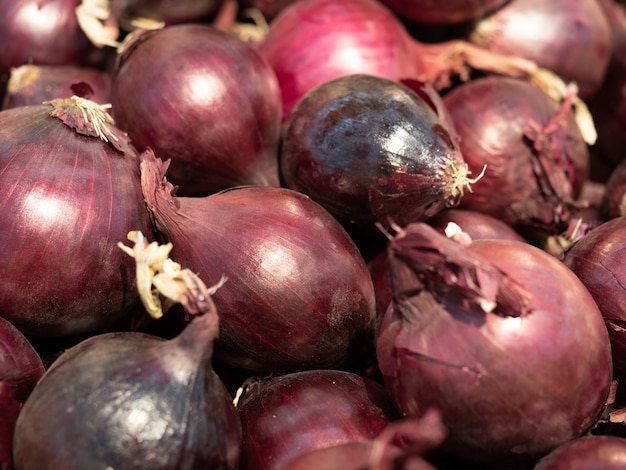 Helder patroon van rode uien dat op de etalage ligt. Sjabloon voor groenten en vegetarisme