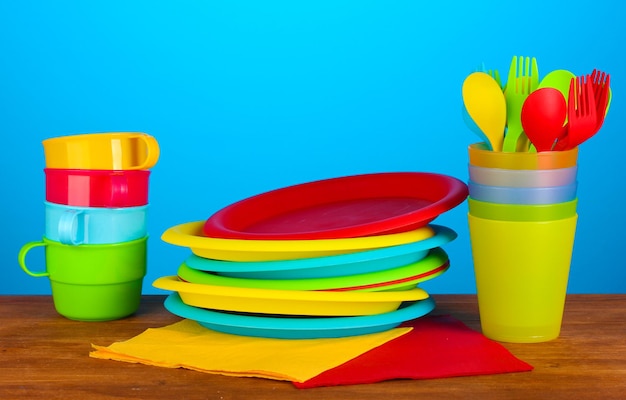 helder plastic wegwerpservies op houten tafel op kleurrijke achtergrond