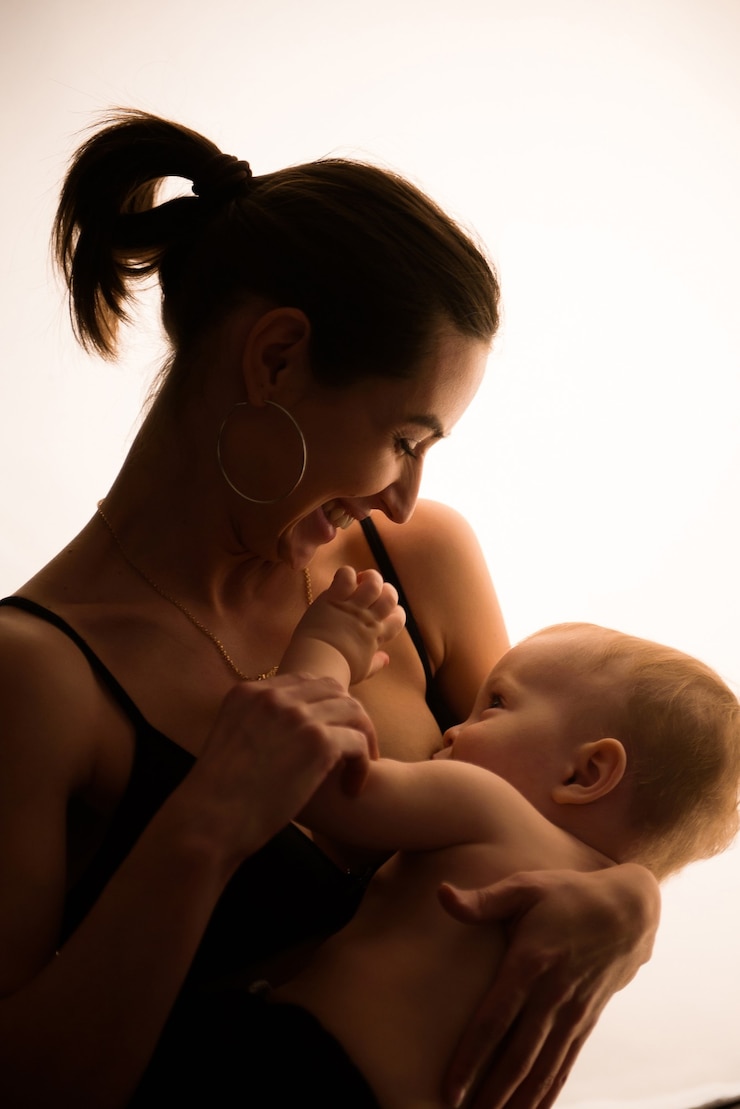 Helder portret van een moeder die de baby borstvoeding geeft.