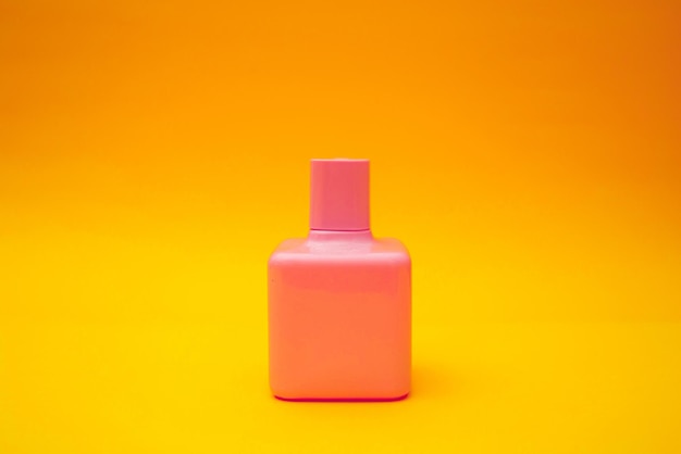 Helder roze parfum op een oranje achtergrond