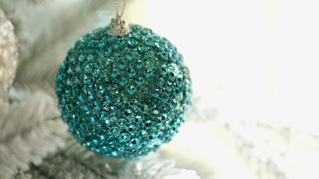 Helderblauwe kerstboombal met glanzende stenen close-up