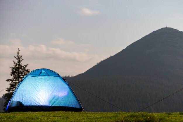 heldere blauwe tent op met gras begroeide boskap