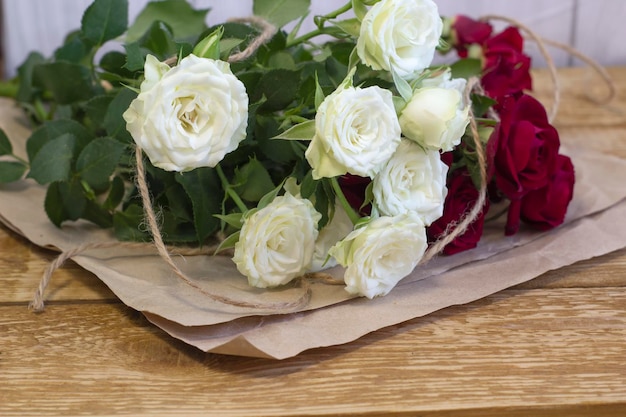 Heldere Bourgondische en gekleurde bloemen in een boeket op bruine houten geweven close-up als achtergrond