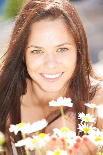 heldere buitenfoto van mooie vrouw met bloemen